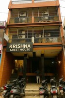 Ein zweistöckiges Gebäude mit der Aufschrift 'KRISHNA GUEST HOUSE'.