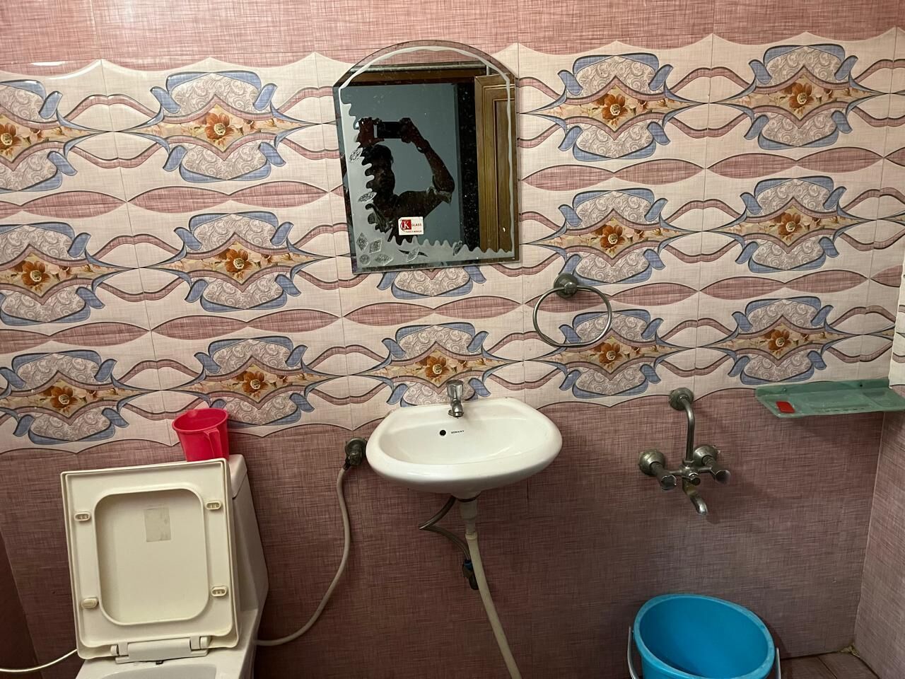 A small bathroom with a toilet, sink, and shower.