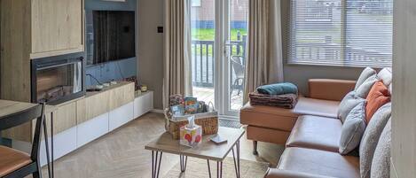 Un salon avec une cheminée, un canapé et une vue sur l’extérieur.
