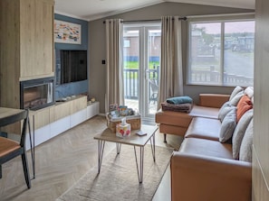 A living room with a fireplace, sofa, and a view of the outdoors.