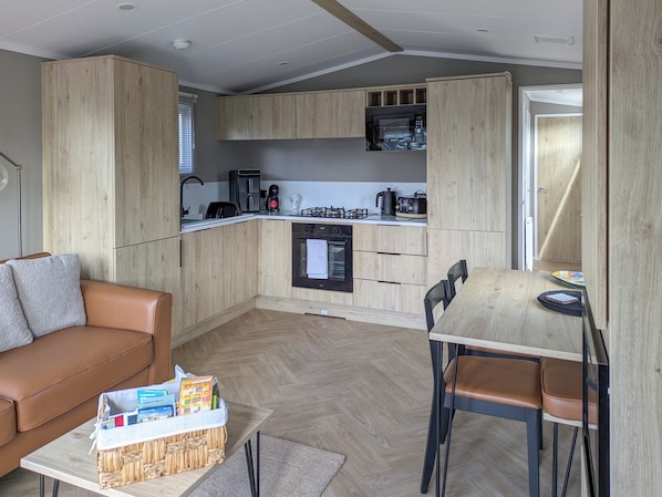 A compact kitchen with wooden cabinets, a built-in microwave, and a gas stove.