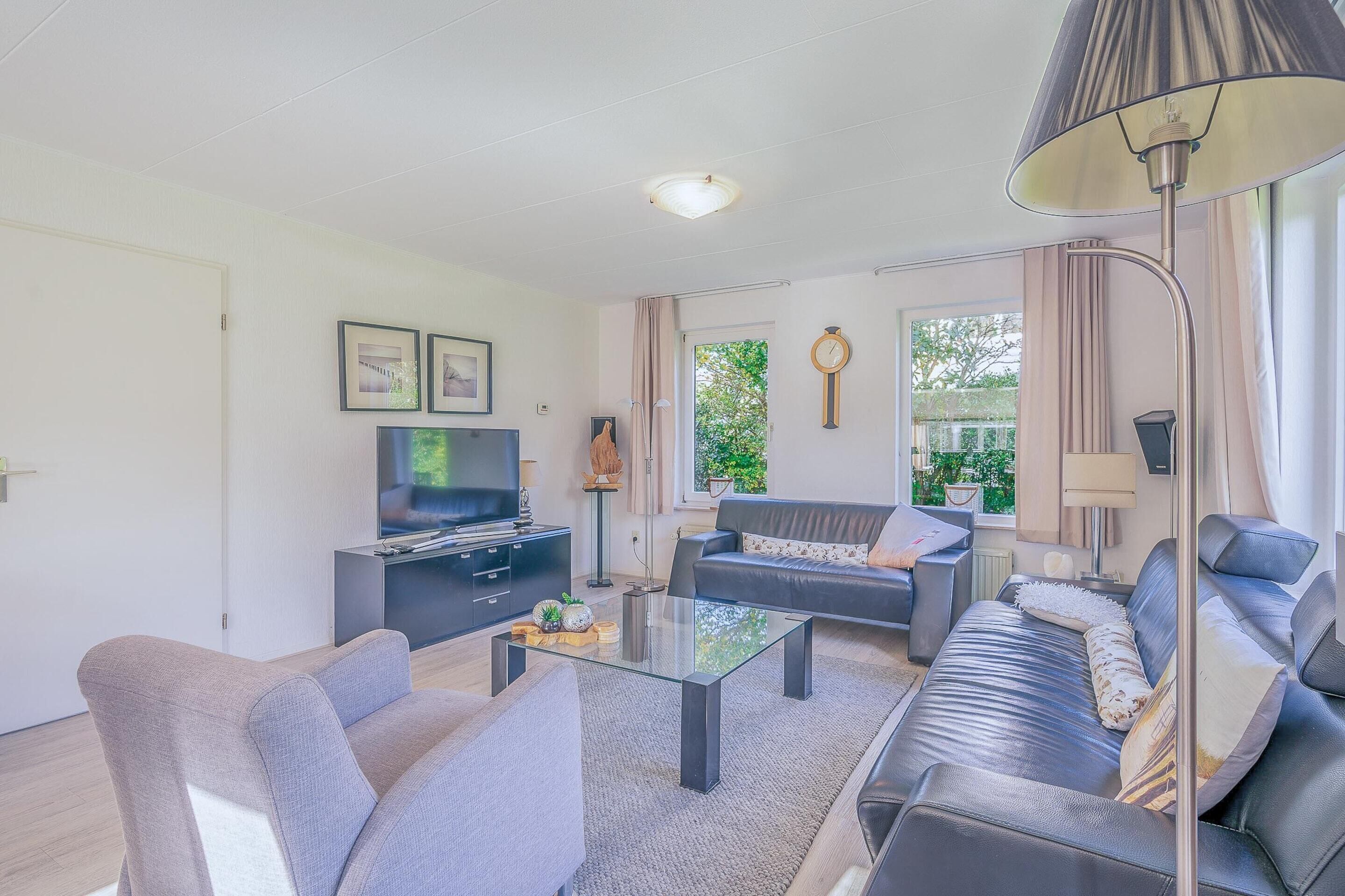 A modern living room with a sofa set, a coffee table, and a TV.