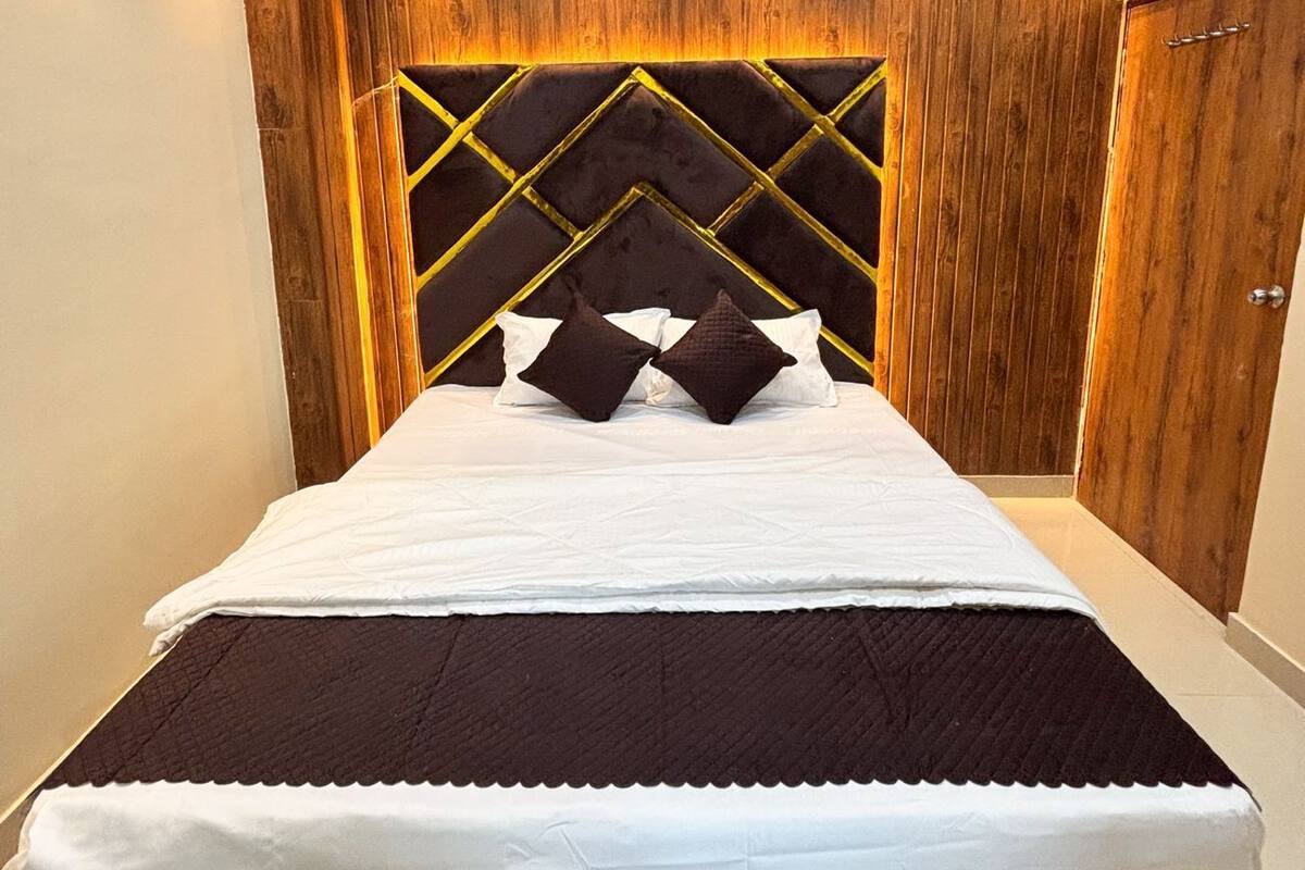 Un dormitorio con una cama grande, cabecera de madera y un armario.