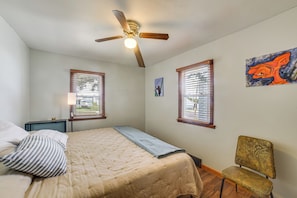 A bedroom with a bed, a chair, a ceiling fan, and two windows with blinds. - Walk to Restaurant & Bar: Home w/ Deck in Gary (Gary)