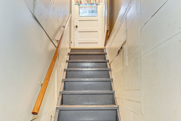 A narrow staircase with wooden handrails and a white door at the top. - Walk to Restaurant & Bar: Home w/ Deck in Gary (Gary)