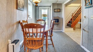 A dining area with a wooden table and chairs, a ceiling fan, and a view of a staircase leading to another room.