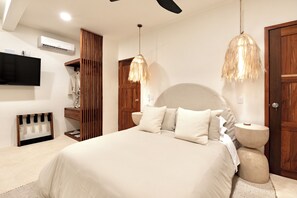 A bedroom with a large bed, wooden wardrobe, and a ceiling fan.