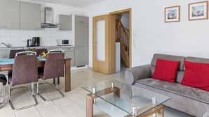 A modern apartment with a dining area, kitchen, and living room. - Holiday home with sauna on the Baltic Sea (Boiensdorf)