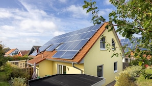 A residential building with solar panels on the roof and a small shed in the foreground. - Group house with sauna on the Baltic Sea (Boiensdorf)