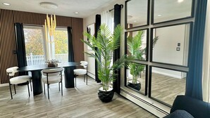 Un espace repas moderne avec une table ronde, des chaises et des plantes en pot.