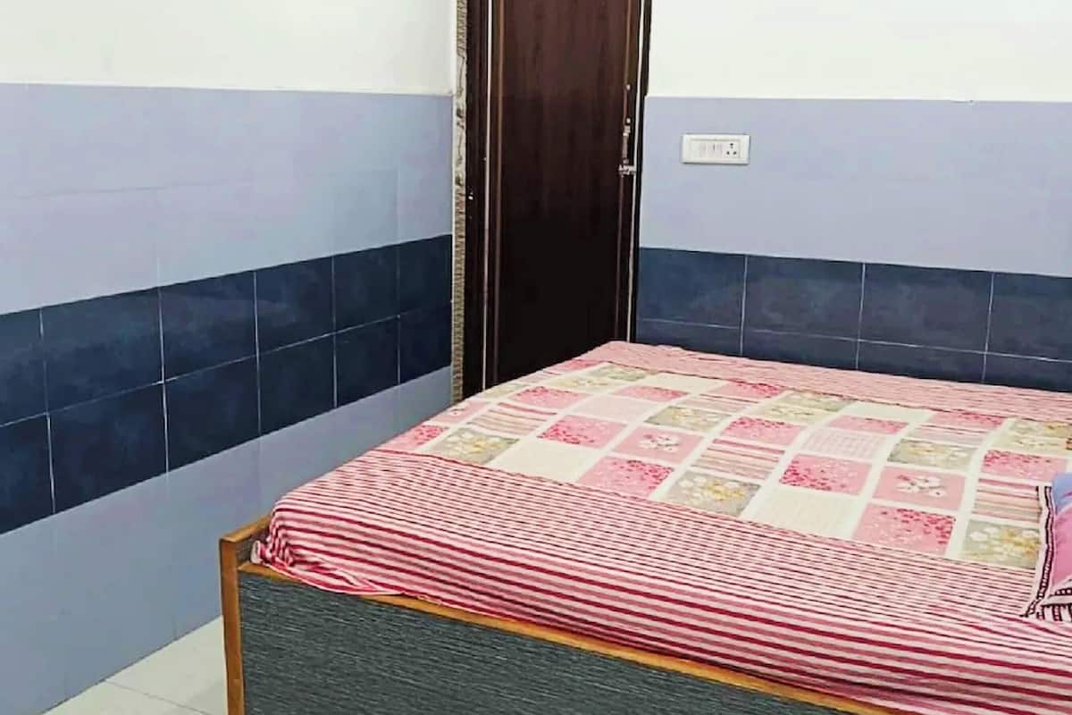 Una camera da letto con un letto, una porta e una parete con decorazioni nei toni del blu e del bianco.