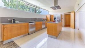 Eine moderne Küche mit Holzschränken, Edelstahlgeräten und einem großen Fenster für natürliches Licht.