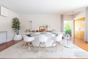 Une salle à manger moderne avec une table ronde, des chaises blanches et une plante en pot.
