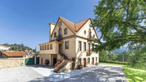 Ein historisches Gebäude mit einer Steintreppe, einem großen Balkon und einem Kopfsteinpflasterhof.