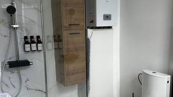 Eenvoudig appartement | Badkamer | Een douche, gratis toiletartikelen, een haardroger, handdoeken