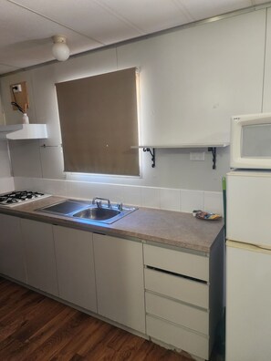 Geladeira, micro-ondas, cooktop, talheres/pratos/utensílios de cozinha