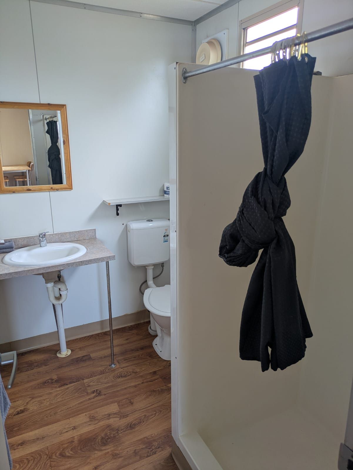 Un bagno con lavandino, WC e tenda della doccia.