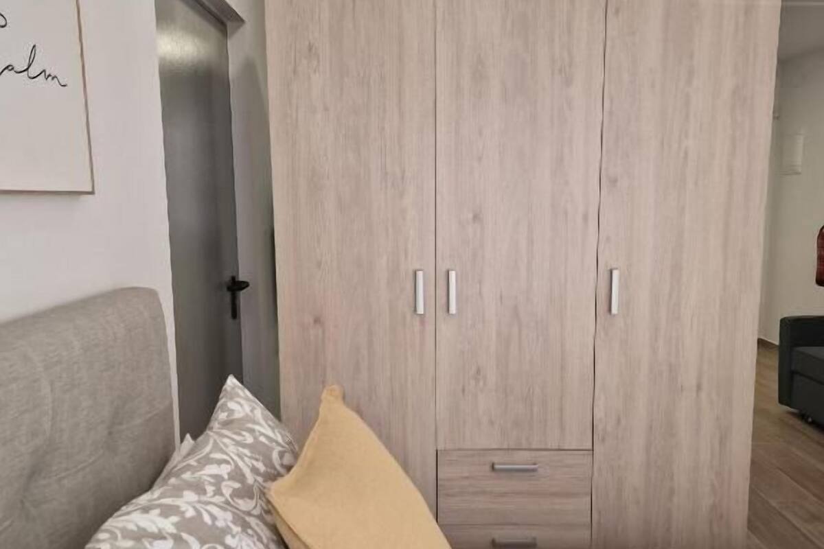Une chambre à coucher avec un lit, une armoire et une porte.