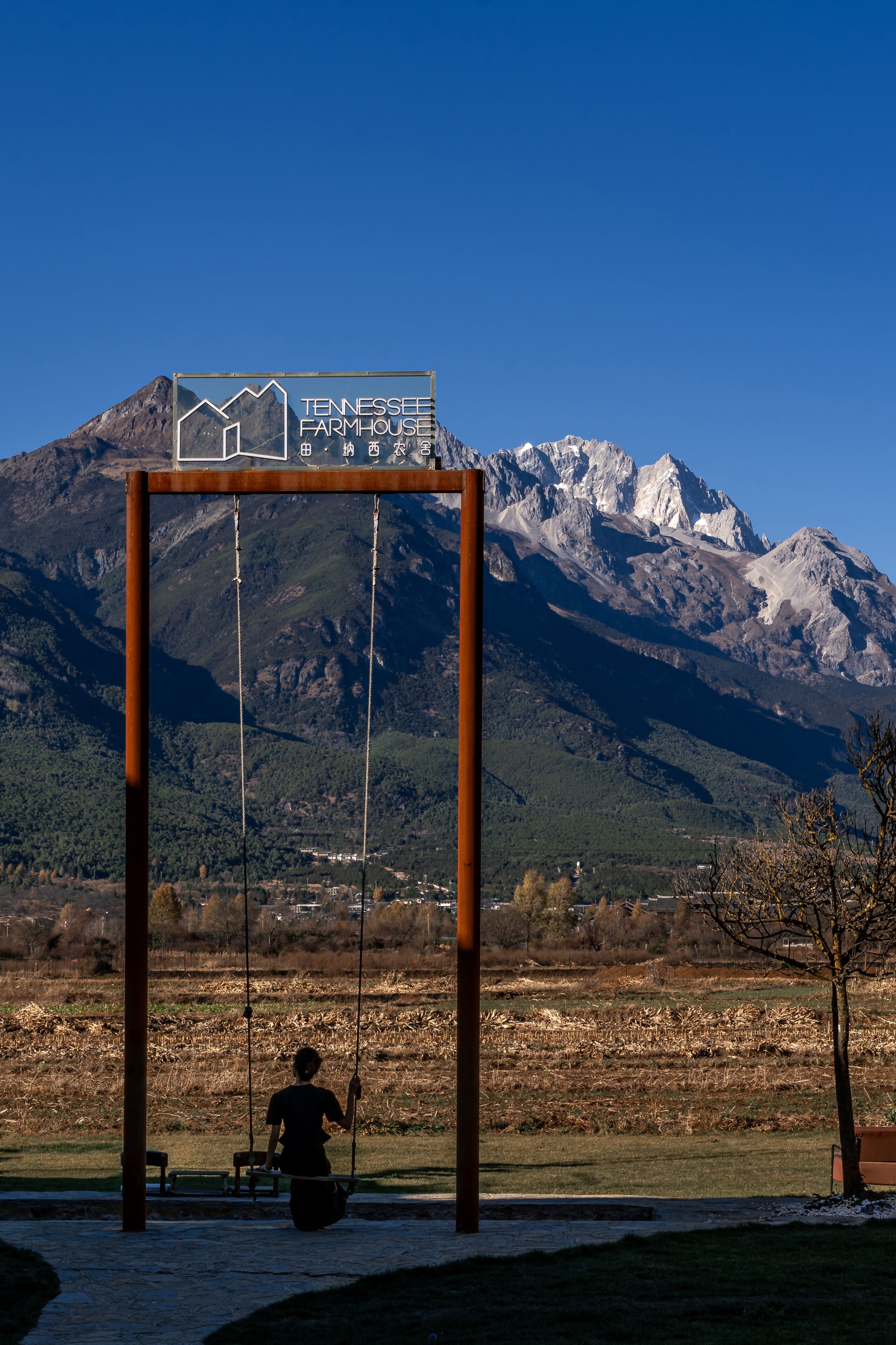 Un tobogan amb un cartell que diu "Tennessee Farmhouse" davant d'un paisatge de muntanyes.
