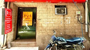 Un hostal llamado Amritsar Backpackers Hostel con una motocicleta estacionada adelante.