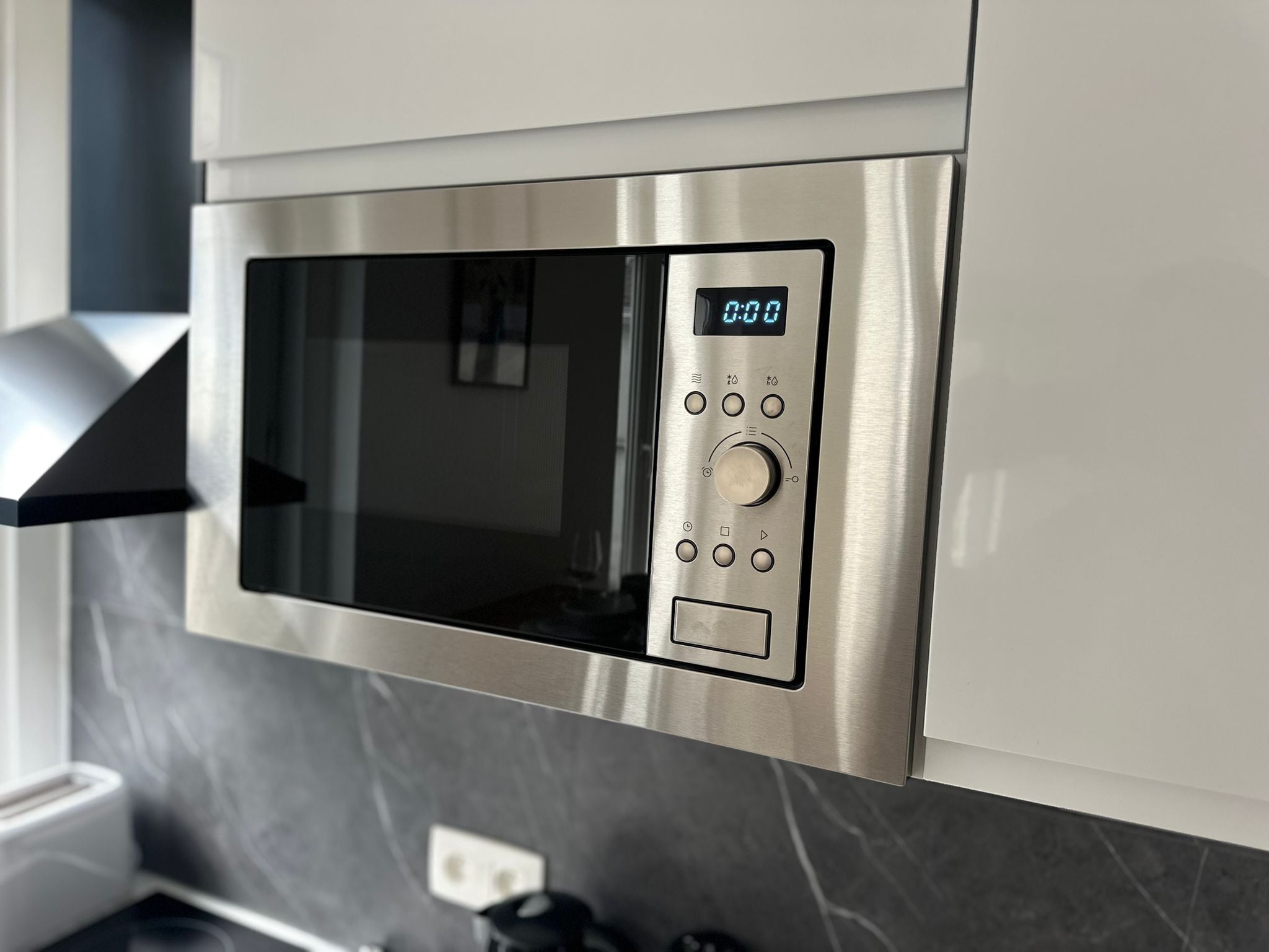 A modern kitchen with a built-in microwave and oven.