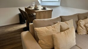 A modern living room with a sofa, a dining table with chairs, and a skylight. - Cozy 1BR plus LR Apt Ghent Gravensteen (Ghent)