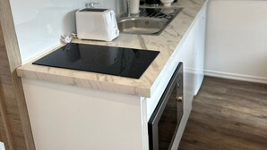 A compact kitchen with a built-in stove, a sink, and a coffee maker. - Cozy 1BR plus LR Apt Ghent Gravensteen (Ghent)