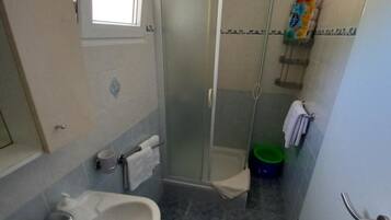 A bathroom with a shower, a sink, and a toilet.