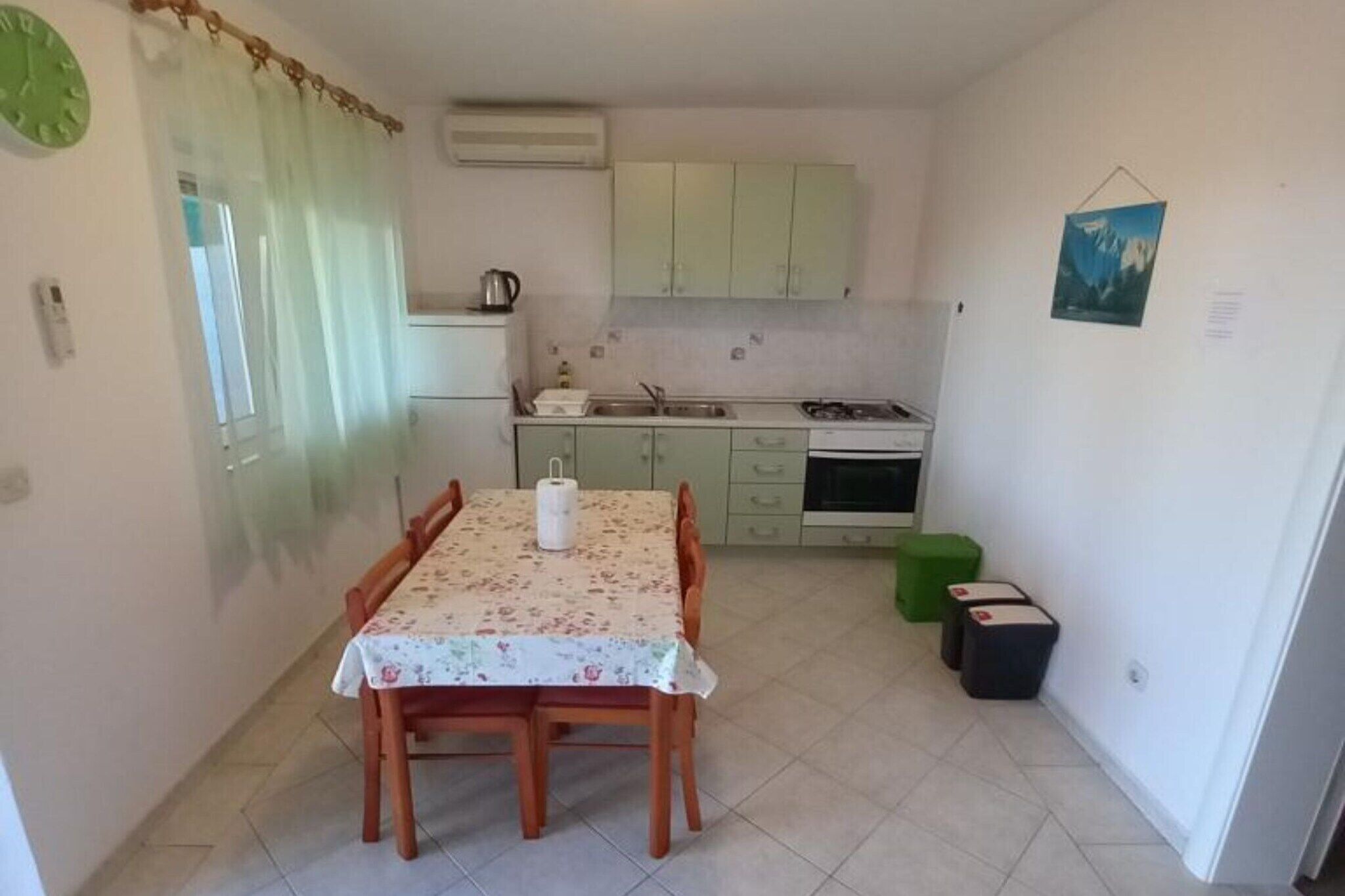 A compact kitchen with a dining table, cabinets, and a small stove.
