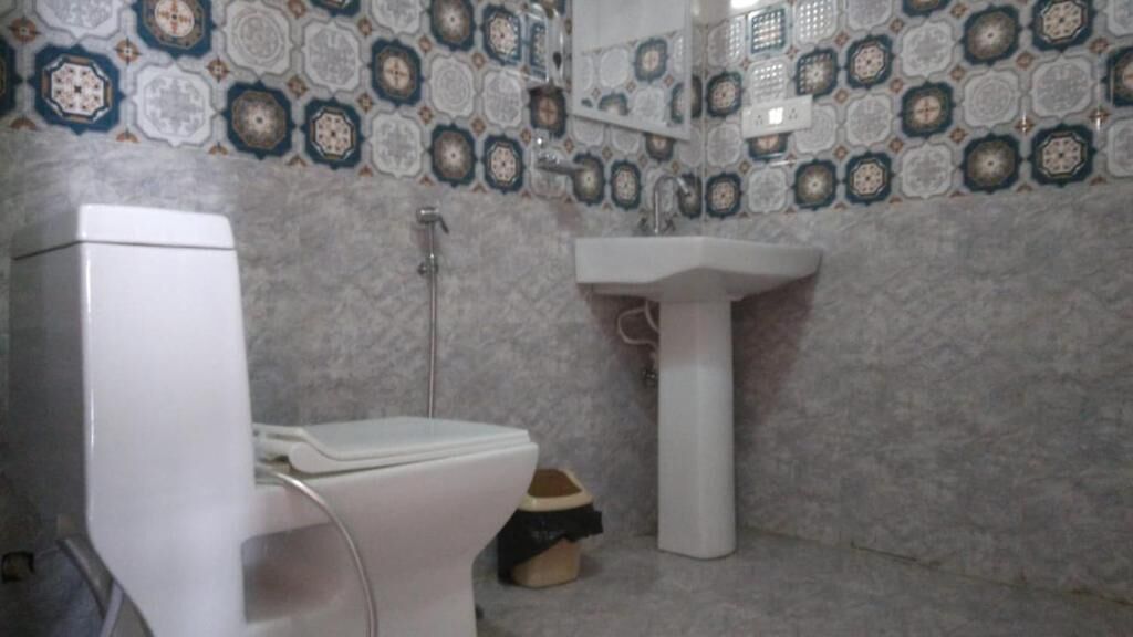 Une salle de bain avec des toilettes, un lavabo et une douche.