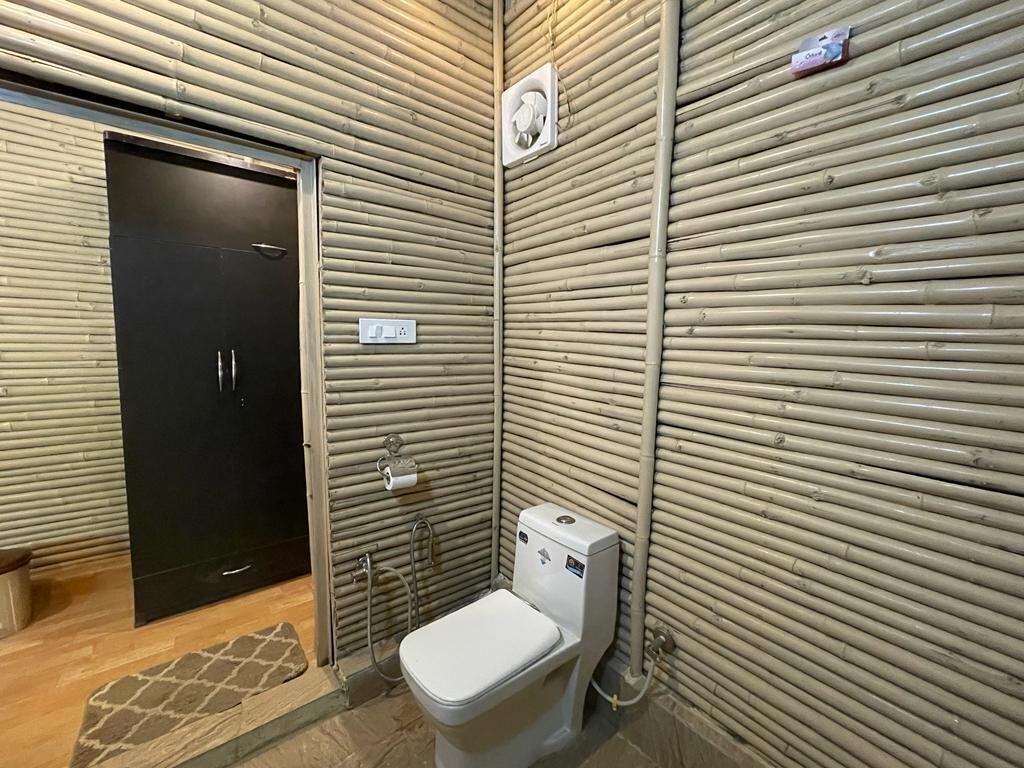 Et lille badeværelse med toilet, håndvask og brusebad.