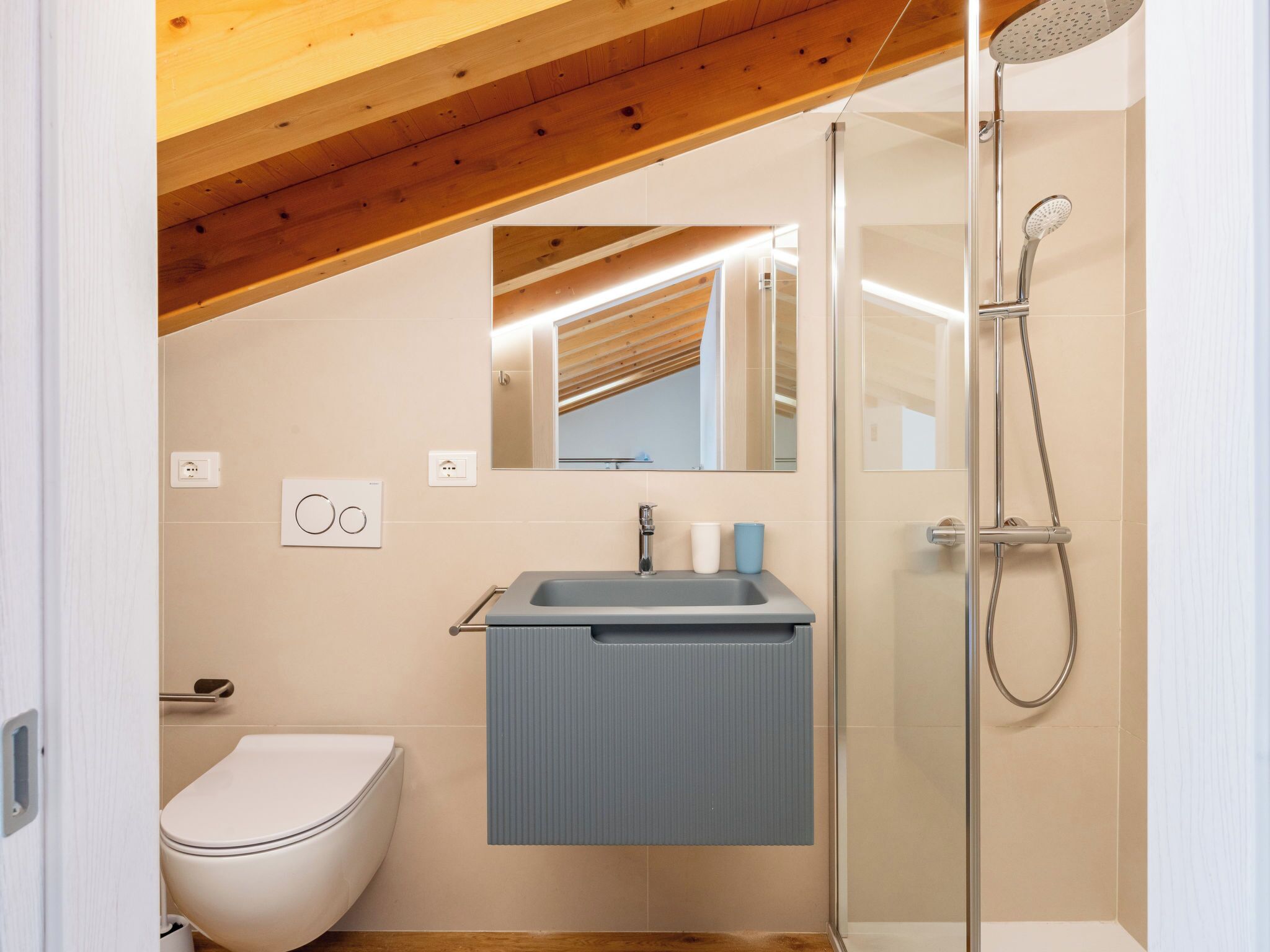 A modern bathroom with a shower, toilet, and sink.