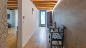 A hallway with wooden beams, a bench, and a door leading to another room. - Vista Lago Consolini by Interhome (Brenzone)