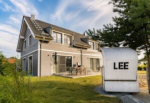 Une maison à deux étages au design moderne, dotée d’un patio couvert et d’une boîte aux lettres portant l’inscription « LEE ».