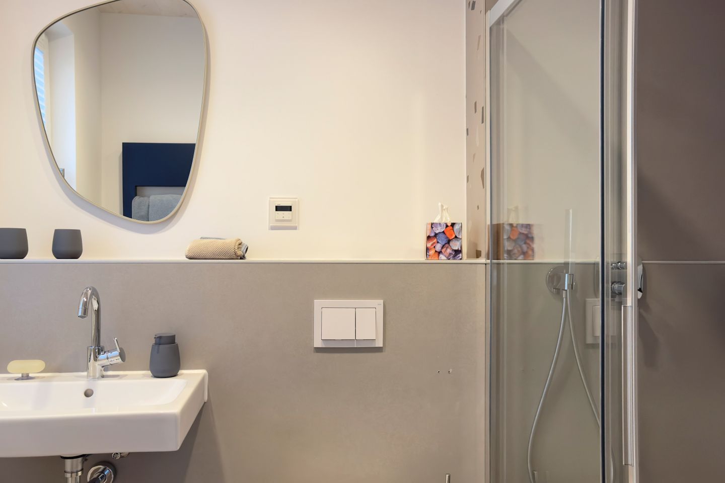 Une salle de bain moderne avec un lavabo, un miroir et une douche.