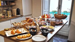 Un bufé de desayuno con pasteles, frutas y bebidas.