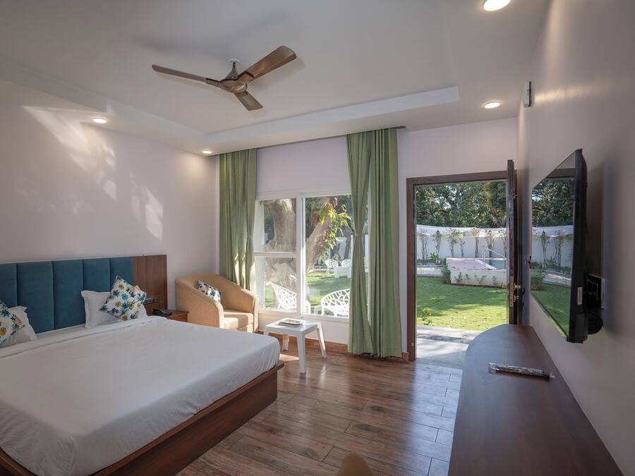 Un dormitorio con una cama grande, un ventilador de techo, un televisor y vistas al exterior.