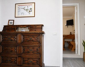 Uma cômoda de madeira com gavetas e um mapa emoldurado na parede acima.