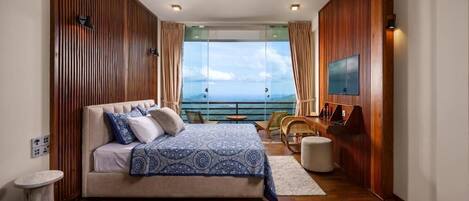 A bedroom with a bed, a TV, a balcony with a view, and wooden paneling.
