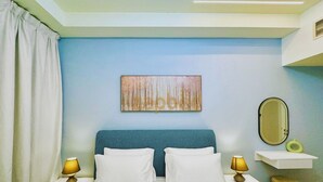 Une chambre à coucher comprenant un lit, deux tables de chevet, une commode, un miroir fixé au mur et un élément décoratif mural.