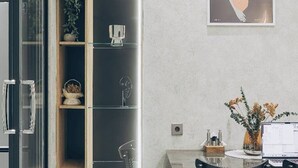 A modern kitchen with a built-in wooden cabinet, a glass door, and a dining area with a table and chairs. - Lev bir (Baku)
