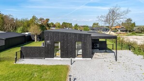 A modern, single-story building with a dark exterior, a visible door, and a small window. - "Barnet" - 180m to the fjord by Interhome (Storvorde)