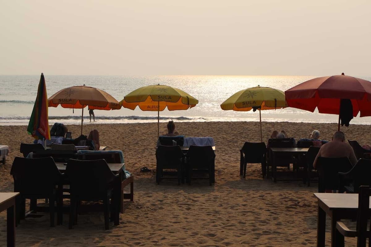 Un restaurante frente al mar con terraza y sombrillas.