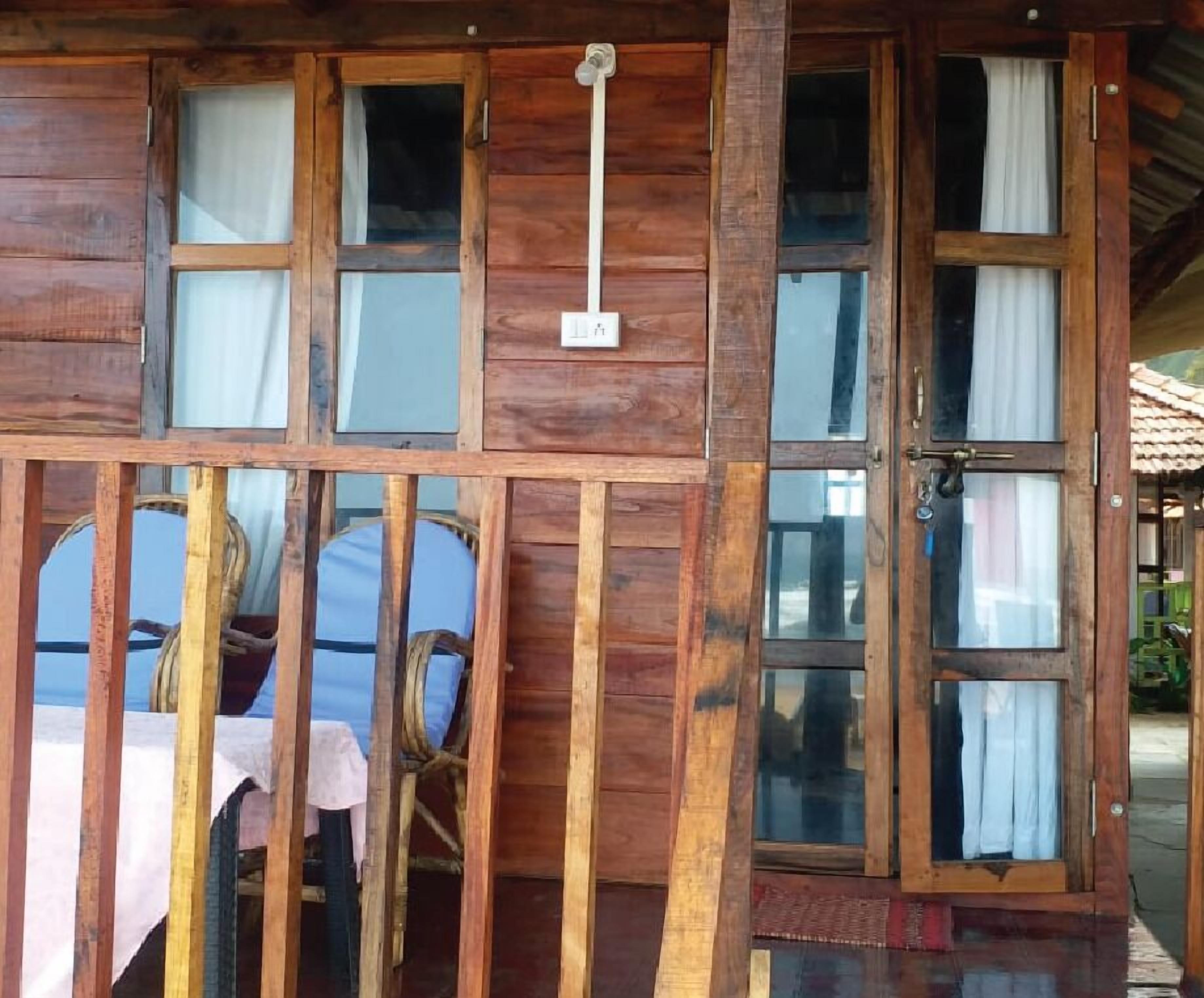 Une cabane en bois dotée de nombreuses fenêtres et d’une porte, présentant un design simple et rustique.