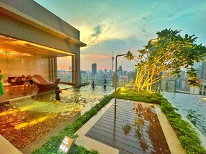 Una piscina al aire libre, sillones reclinables de piscina