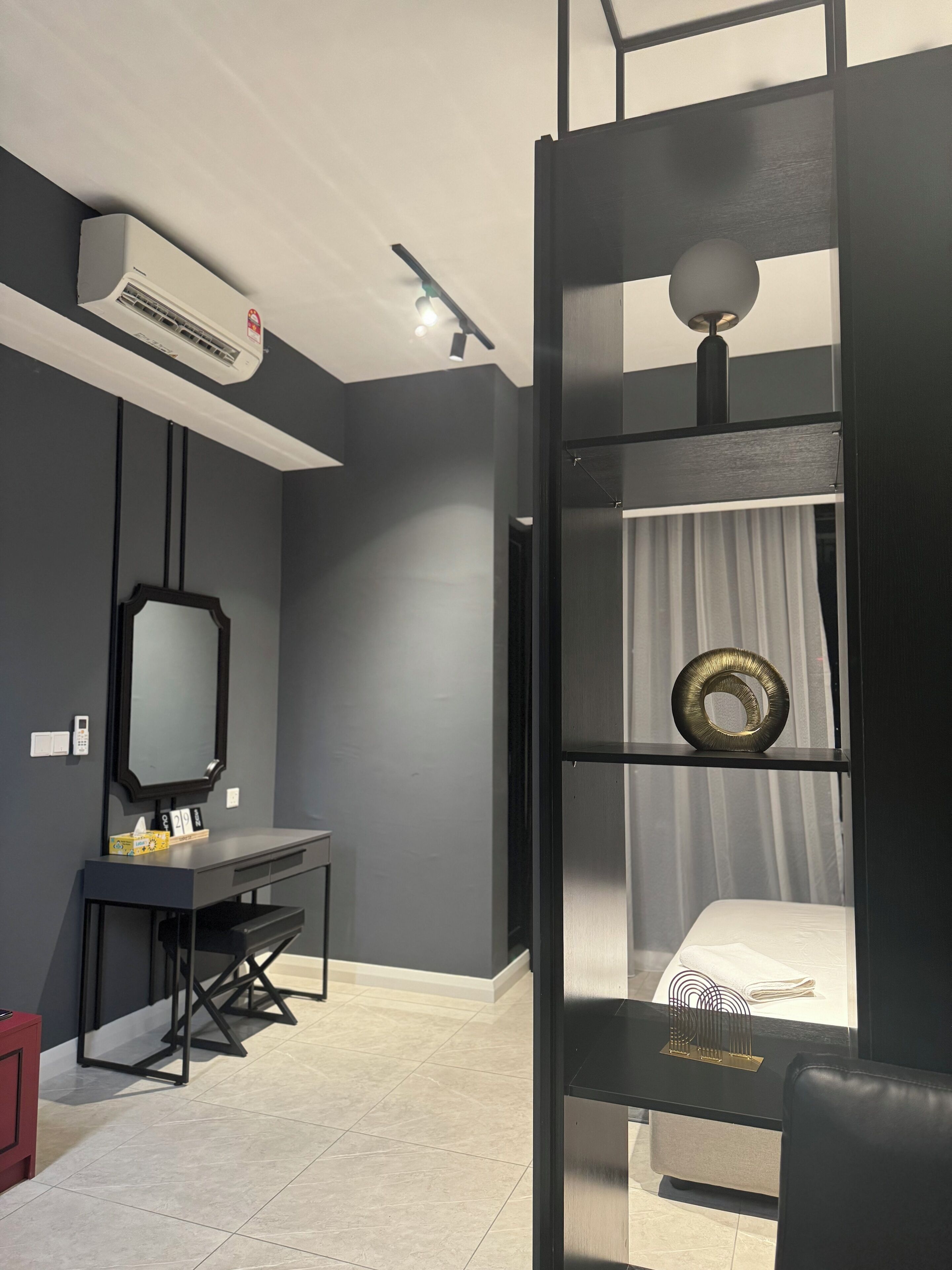Une chambre moderne avec un lit superposé, un bureau, un miroir et un climatiseur fixé au plafond.