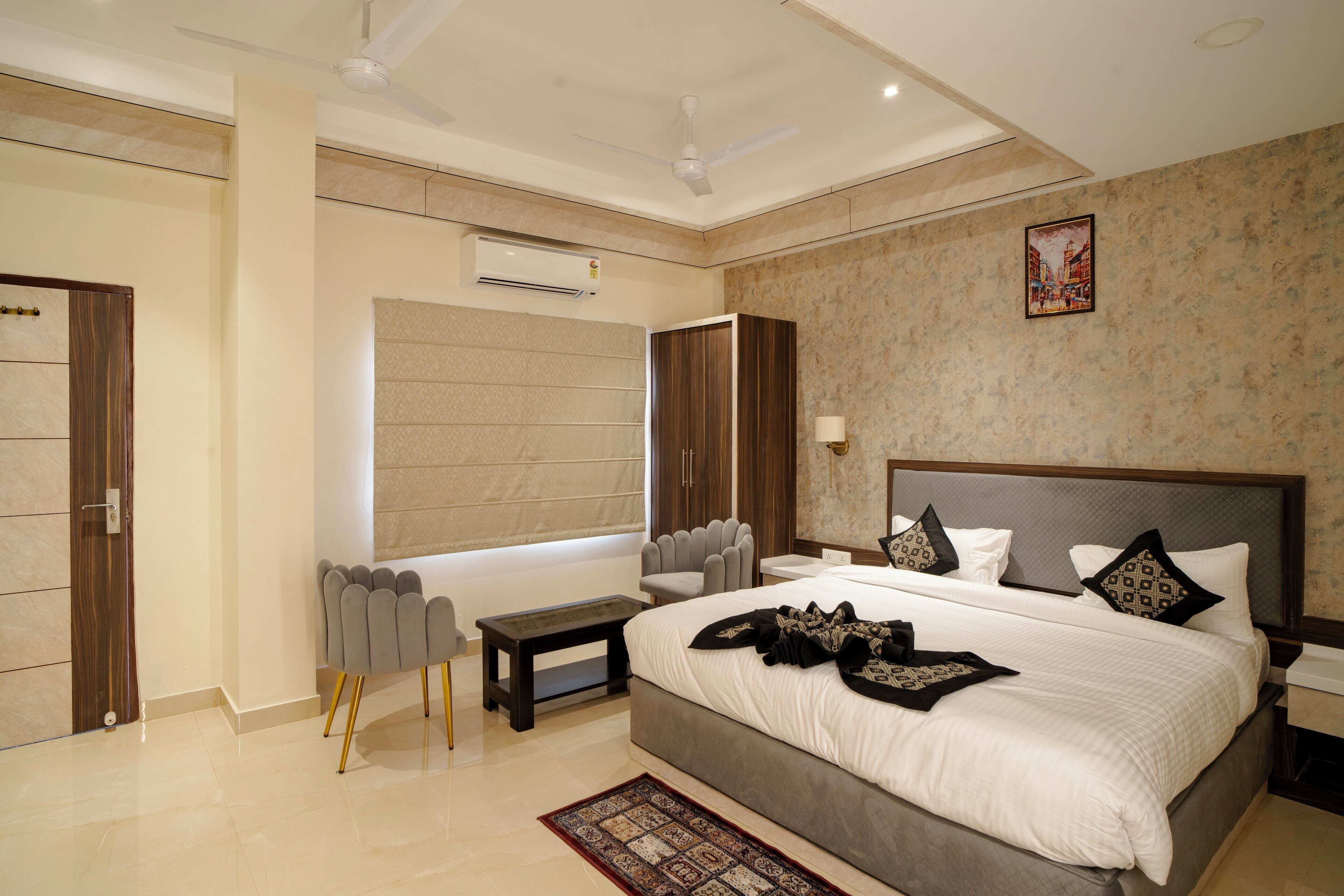 A modern bedroom with a large bed, bedside tables, a desk, and a chair.