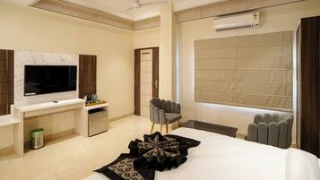 Une chambre d’hôtel moderne équipée d’un grand lit, d’un téléviseur à écran plat, d’un bureau et d’une chaise.