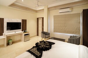Une chambre d’hôtel moderne équipée d’un grand lit, d’un téléviseur à écran plat, d’un bureau et d’une chaise.