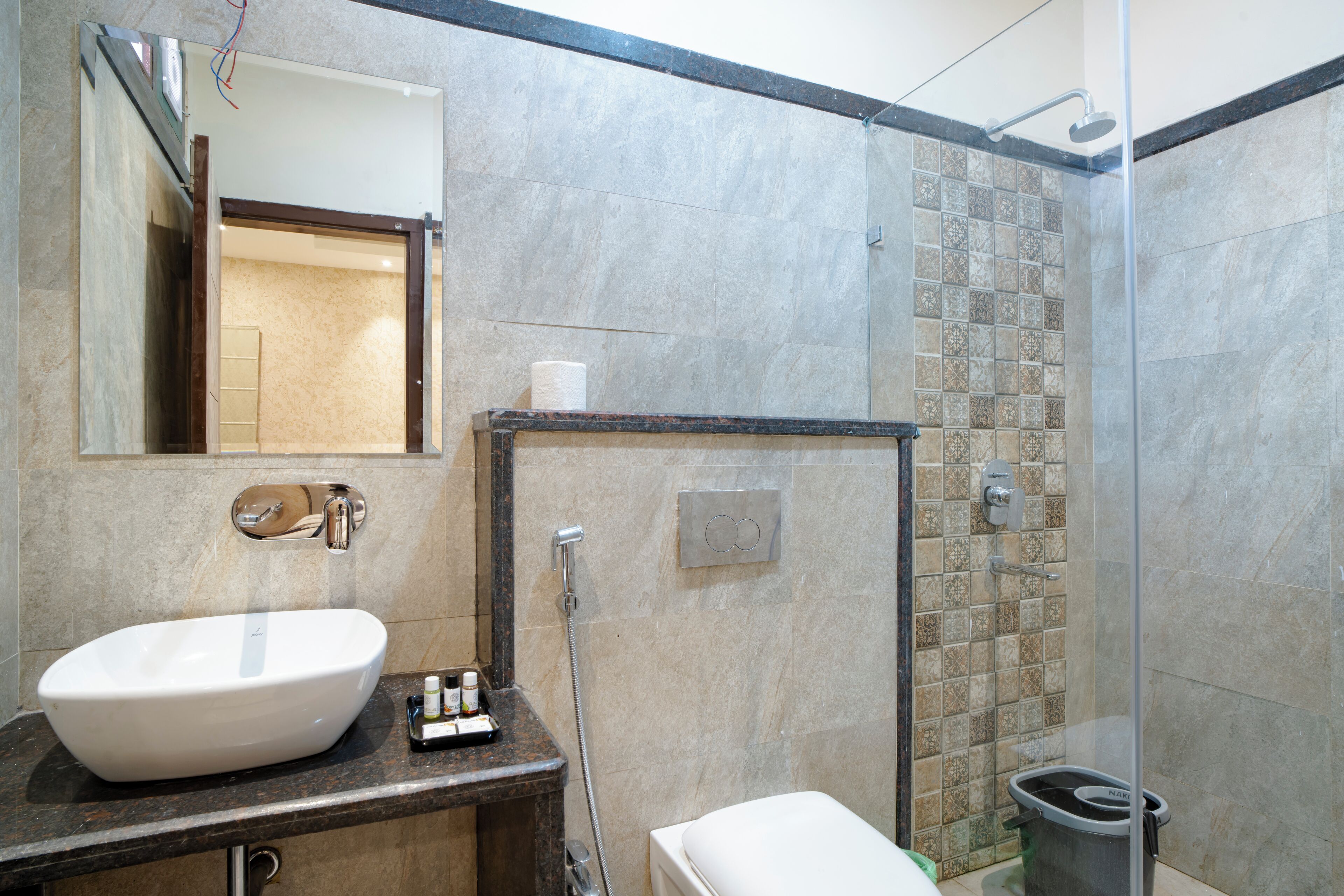 Un baño con un lavamanos grande de color blanco, un espejo, una ducha y un inodoro.